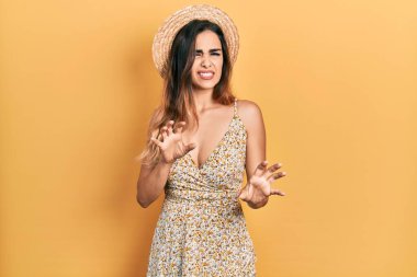 Yaz şapkası takan genç İspanyol kız tiksinti ifadesi takınıyordu. Tiksinti tepkisi yüzünden tiksinti ve korku ifadesi takınıyordu. Eller havada. 