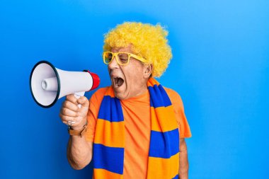 Gözlüklü, peruk takan ve megafonla bağıran son sınıf İspanyol holigan adam.