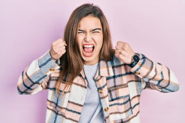 Kafkasyalı genç bir kız, kızgın ve kızgın. Öfkeyle bağırırken kızgın ve öfkeli yumruklar sallıyor. öfke ve agresif konsept. 