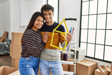 Genç latin çift gülümsüyor Mutlu ev projeleri yeni evinde tutuluyor.