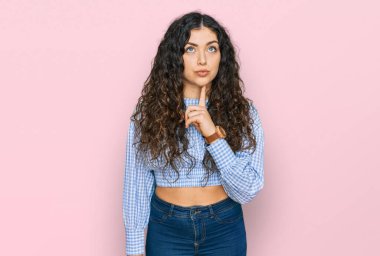 Gündelik kıyafetler giyen genç İspanyol kız şüphe üzerine yoğunlaşmıştı. Parmakları çenesinde ve yukarı bakıyordu. 