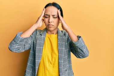 Genç İspanyol kız iş kıyafetleri giyiyor. Baş ağrısı, çaresiz ve stresli. Ağrı ve migren yüzünden. Eller başının üstünde.. 