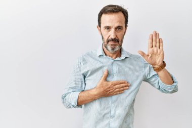 Orta yaşlı, sakallı, soyutlanmış bir geçmişi olan, elleri göğsünde ve avuçları açık yemin eden, sadakat yemini eden İspanyol bir adam. 