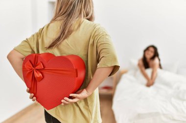 Genç bir kadın yatak odasında sevgilisine sevgililer günü hediyesiyle sürpriz yapıyor..