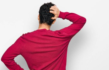 Genç ve yakışıklı bir adam günlük kıyafetlerini ters giyip elleri kafasında şüpheyi düşünüyor. 