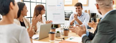 Ofisteki ortağına gülümseyen ve alkışlayan bir grup işçi..