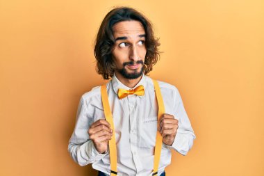 Genç İspanyol bir adam şık giyinmiş. Gülümsüyor, yan tarafa bakıyor ve düşünüyor.. 