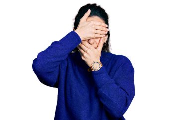 Gündelik kıyafetler giyen genç İspanyol kadın gözlerini ve ağzını elleriyle kapatıyor, şaşırmış ve şok olmuş. duygu gizleme 