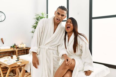 Havlu giymiş genç bir Latin çift güzellik merkezinde öfkeli ve kızgın bir şekilde bağırıyor öfkeyle bağırıyor. öfke ve agresif konsept. 