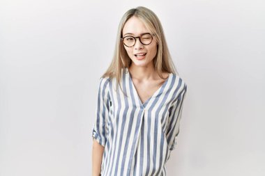 Asyalı genç bir kadın, günlük kıyafetler ve gözlük takıyor kameraya seksi bir ifadeyle bakıyor, neşeli ve mutlu bir yüzle.. 