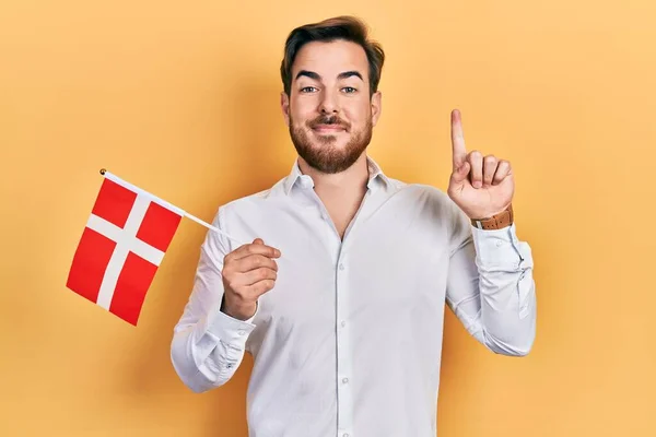 Przystojny Biały Mężczyzna Brodą Trzymający Flagę Denmarka Uśmiechający Się Pomysłem — Zdjęcie stockowe