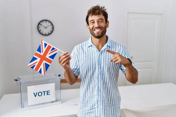 英俊潇洒的年轻人在选战中举着英国国旗 兴高采烈地手指手画脚 — 图库照片