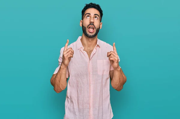 Латиноамериканец Бородой Повседневной Рубашке Удивлен Удивлен Глядя Вверх Указывая Пальцами — стоковое фото