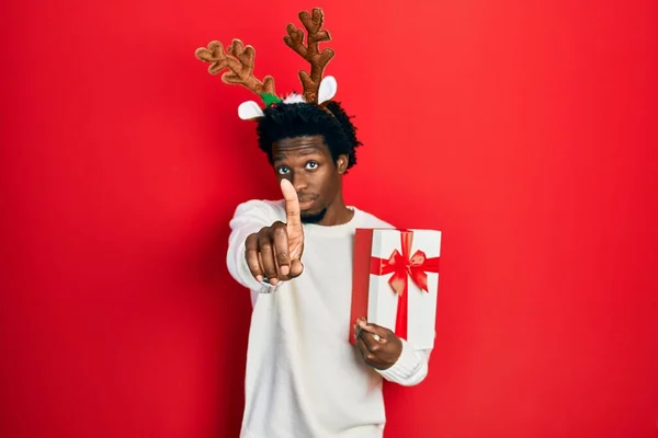 Jovem Afro Americano Vestindo Chapéu Natal Veado Segurando Presente Apontando — Fotografia de Stock