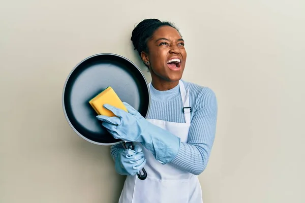 Mujer Afroamericana Con Pelo Trenzado Usando Delantal Sosteniendo Scourer Lavando —  Fotos de Stock
