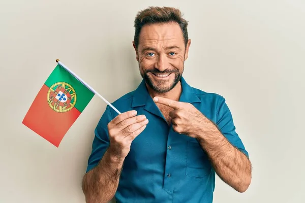 Medelålders Man Håller Portugal Flagga Ler Glad Pekar Med Hand — Stockfoto
