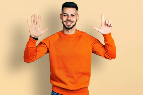 Mladý Hispánec Vousy Sobě Příležitostný Oranžový Svetr Ukazuje Ukazuje Prsty — Stock fotografie