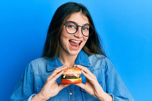 Joven Mujer Caucásica Comiendo Una Sabrosa Hamburguesa Clásica Sonriendo Riendo —  Fotos de Stock