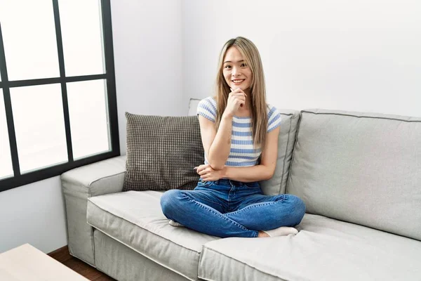 Asiatisk Ung Kvinna Sitter Soffan Hemma Ser Säker Kameran Ler — Stockfoto