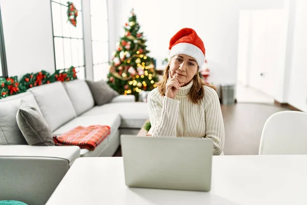 Frau Mittleren Alters Trägt Weihnachtsmannmütze Mit Laptop Ernstes Gesicht Das — Stockfoto