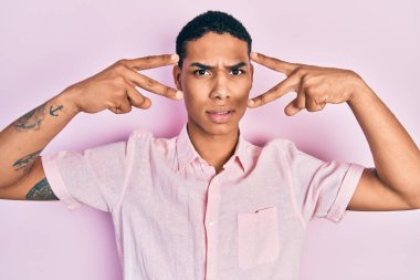 Genç Afrikalı Amerikalı adam zafer işareti yapıyor ve barış jesti cahil ve kafası karışık. şüphe kavramı. 