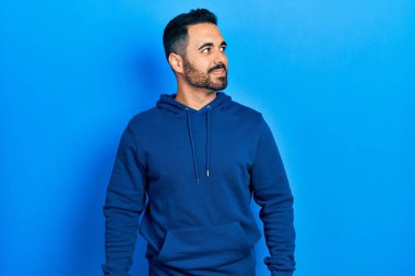 Yakışıklı, sakallı, sıradan bir kazak giyen, rahat bir görünüm takınan, doğal yüzlü ve kendine güvenen bir gülümseme takınan bir İspanyol.. 