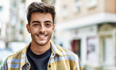 Yakışıklı İspanyol adam şehirde mutlu ve kendinden emin gülümsüyor.