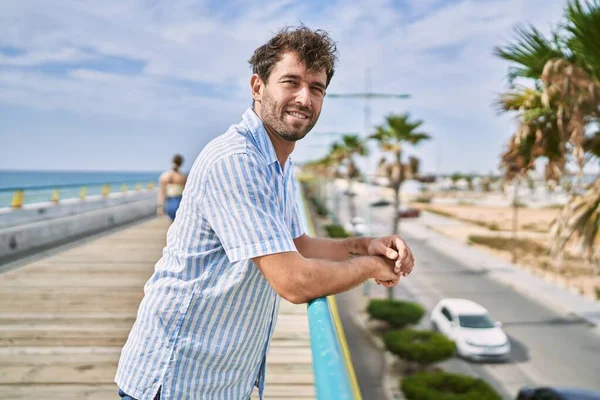 Ung Latinamerikansk Man Ler Lycklig Stående Vid Strandpromenaden — Stockfoto