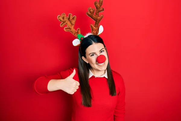 Mladá Hispánka Jelením Vánočním Kloboukem Červeným Nosem Dělá Šťastné Gesto — Stock fotografie