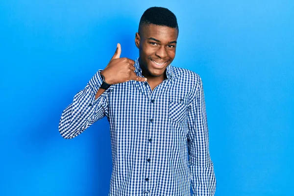 若いアフリカ系アメリカ人の男性は 携帯電話で話すような手や指で携帯電話のジェスチャーをして笑顔カジュアルな服を着ていた コミュニケーションの概念 — ストック写真