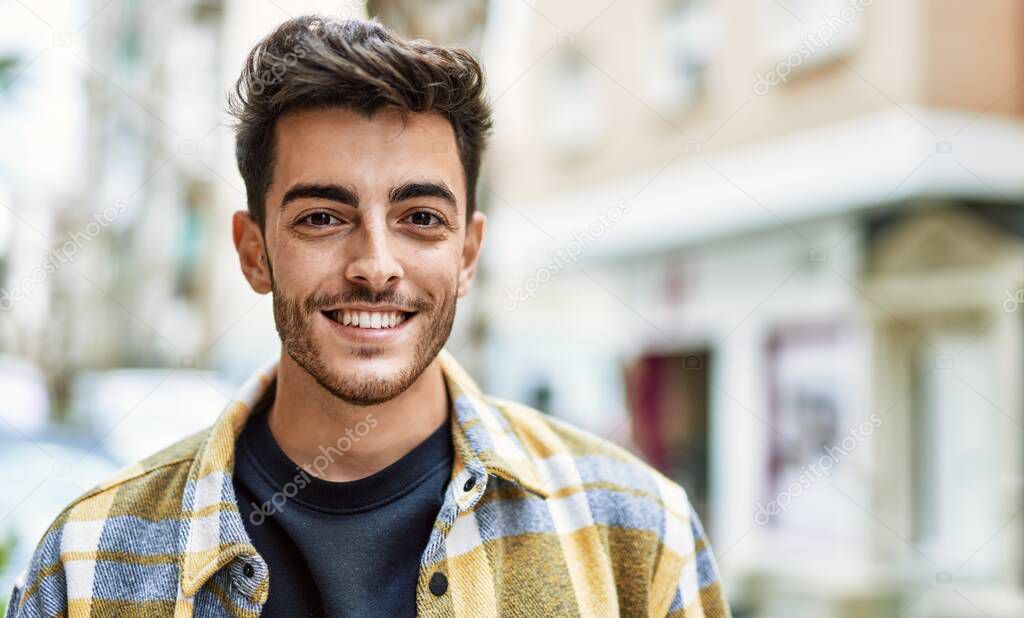 Handsome hispanic man smiling happy and confident at the city