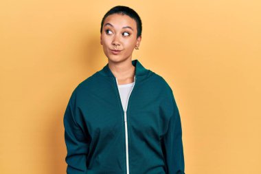 Kısa saçlı güzel İspanyol kadın spor ceket giyiyor gülümsüyor yan tarafa bakıyor ve düşünüyor.. 