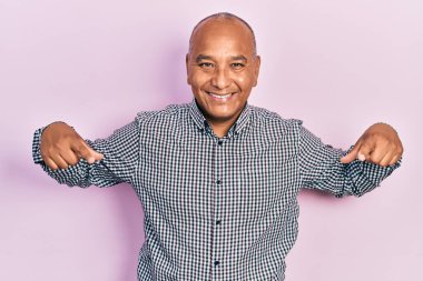 Orta yaşlı, gündelik kıyafetler giyen, kendine güvenen, gülümseyen, kendini gururlu ve mutlu gösteren bir adam.. 