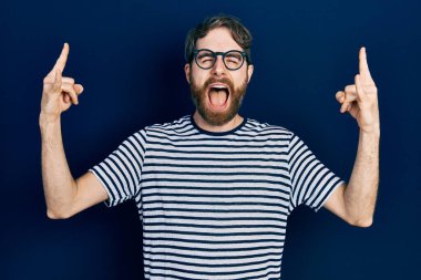 Beyaz, sakallı, çizgili tişörtlü ve gözlüklü çılgın bir ifadeyle bağıran elleri havada rock sembolü yapan bir adam. Müzik yıldızı. ağır kavram. 