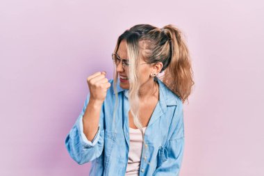 Güzel, genç, sarışın bir kadın. Günlük kıyafetler ve gözlük takıyor. Kızgın ve kızgın. öfke ve agresif konsept. 