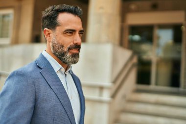 Orta yaşlı işadamı şehirde mutlu mesut dikilirken.