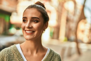 Güzel esmer kadın güler yüzlü mutlu ve kendinden emin sonbaharın güneşli bir gününde şehirde.