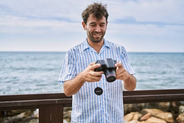 Fiatal Spanyol Férfi Mosolyog Boldog Segítségével Fényképezőgép Strandon — Stock Fotó