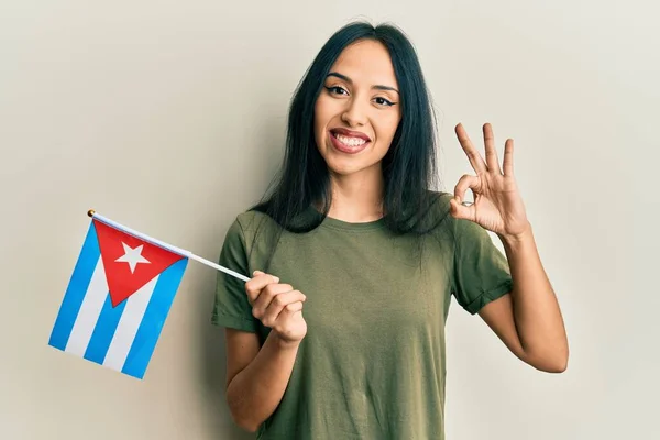Młoda Latynoska Dziewczyna Trzyma Flagę Kuby Robi Znak Palcami Uśmiechając — Zdjęcie stockowe