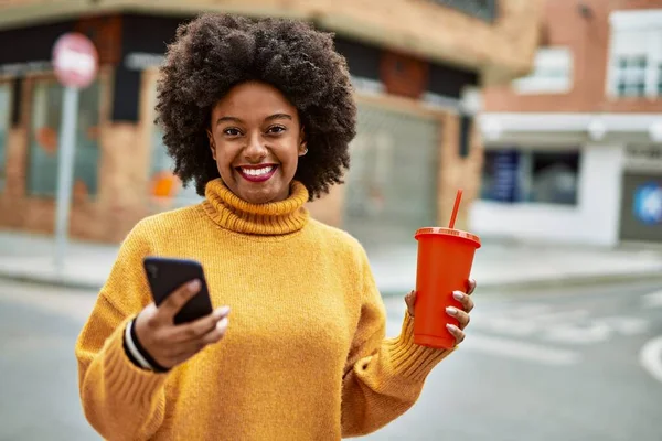 年轻的非洲裔美国女孩在城市里用智能手机喝苏打水 — 图库照片