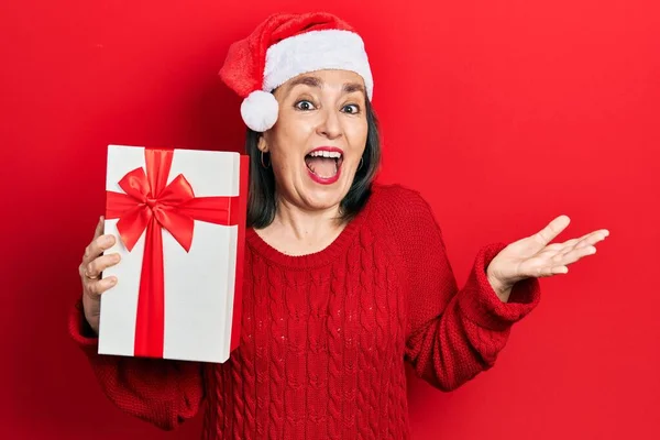 Middle Age Hispanic Woman Wearing Christmas Hat Holding Gift Celebrating — Stock Photo, Image