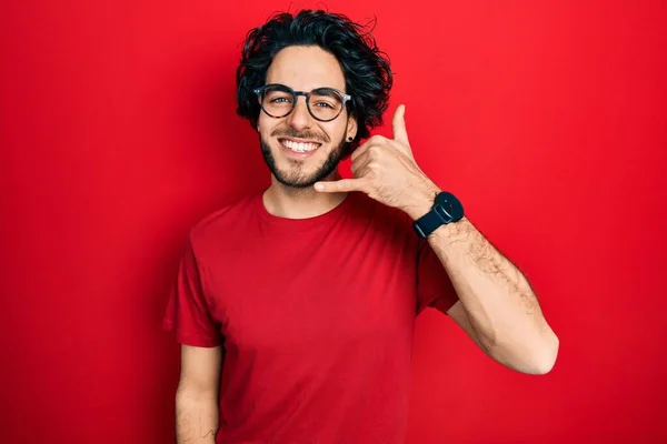 携帯電話で話すような手や指で携帯電話のジェスチャーを行う笑顔のシャツやメガネをカジュアルな姿のハンサムなヒスパニック系の男 コミュニケーションの概念 — ストック写真