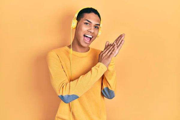 Joven Afroamericano Chico Escuchando Música Usando Auriculares Aplaudiendo Aplaudiendo Feliz —  Fotos de Stock