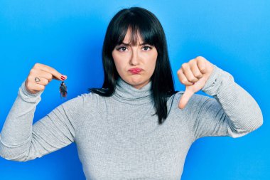 Hamamböceği tutan genç İspanyol kadın kızgın yüzlü, negatif işaret baş parmakları aşağıda, reddedilme konsepti 