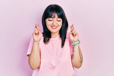 Günlük kıyafetler giyen genç İspanyol kadın umut ve gözlerin kapalı gülümseyerek bana işaret etti. Şans ve batıl inançlar. 