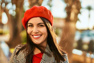 Genç İspanyol kadın gülümseyerek şehirde mutlu mesut dikiliyor..