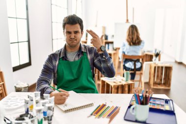 Sanat stüdyosunda genç bir sanatçı kendini vuruyor ve öldürüyor. Elini ve parmaklarını silah gibi kullanıyor. İntihar jesti.. 
