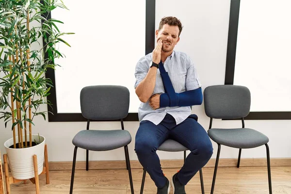 Stilig Ung Man Sitter Läkare Väntrum Med Arm Skada Röra — Stockfoto