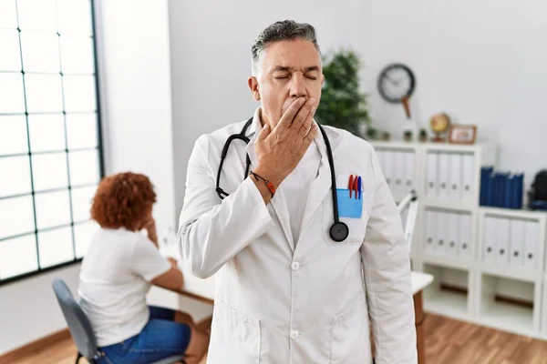 Lekarz Średnim Wieku Pacjentem Znudzonym Ziewaniem Zmęczonym Zakrywaniem Ust Ręką — Zdjęcie stockowe