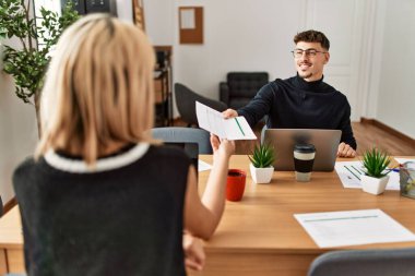 Ofiste dizüstü bilgisayarla çalışırken gülümseyen iki iş adamı..